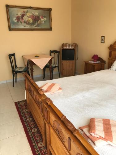 a bedroom with a bed and a table and a television at Falubíró Vendégháza in Bekölce