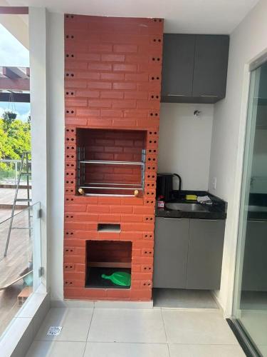 a kitchen with a brick wall in the corner at Apartamento no Atalaia - Salinas/Pa in Salinópolis