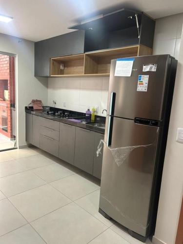 a kitchen with a stainless steel refrigerator and cabinets at Apartamento no Atalaia - Salinas/Pa in Salinópolis