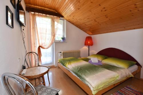 a bedroom with a bed and a table and a window at Privát Lujza in Liptovská Osada