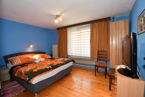 a bedroom with a bed and a flat screen tv at Privát Lujza in Liptovská Osada