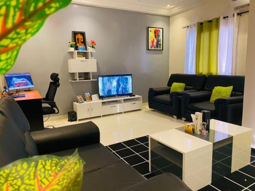 a living room with two couches and a television at Appartement de charme à Dakar in Dakar
