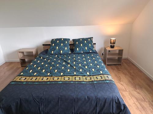 a bedroom with a large bed with blue sheets and pillows at La maison d isa in Lens