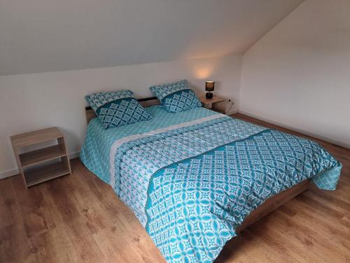 une chambre avec un lit avec une couette bleue dans l'établissement La maison d isa, à Lens