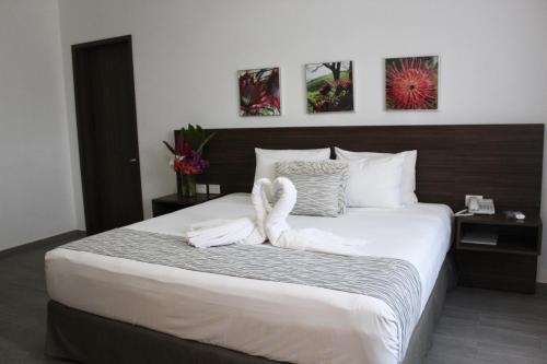 a bedroom with a large bed with swans on it at Mesón de la Luna Hotel & Spa in Mérida