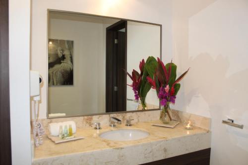 a bathroom with a sink and a large mirror at Mesón de la Luna Hotel & Spa in Mérida