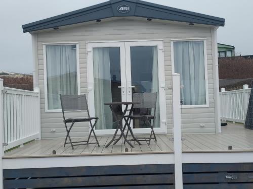 a house with two chairs and a table on a deck at Luxury caravan in Morecambe