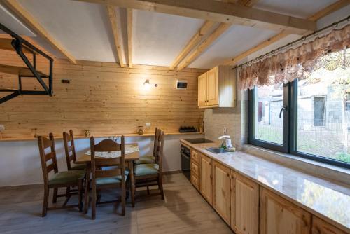 una cocina con mesa y sillas y una ventana en CABANA DIN POIANA, en Poiana Mărului