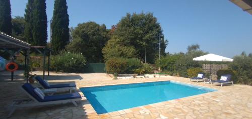 una piscina en un patio con 2 tumbonas en Villa Kalokairi en Áfra