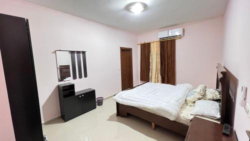 a bedroom with a bed and a television in it at Sara apartment in Wadi Musa