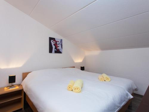 sypialnia z białym łóżkiem i 2 ręcznikami w obiekcie Apartment Červar w Poreču