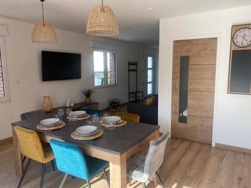 a dining room and living room with a table and chairs at Gîte et Spa L' Echappee Feerique in Fresnicourt-le-Dolmen