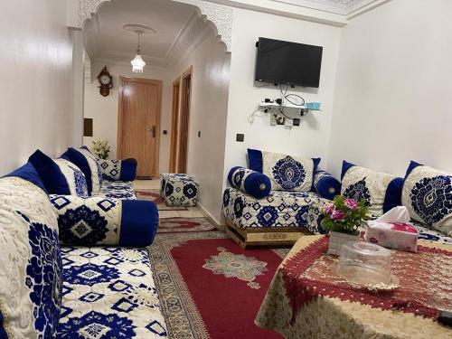 een woonkamer met een bank en een tv bij Centre Sala Al Jadida in Oulad Yakoub