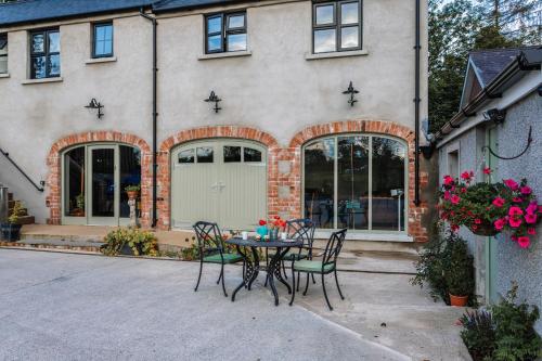 a patio with a table and chairs in front of a house at Lisnacurran in Hillsborough