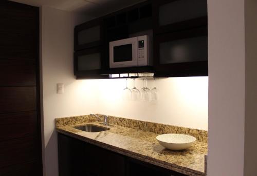 a kitchen counter with a sink and a microwave at Mesón de la Luna Hotel & Spa in Mérida