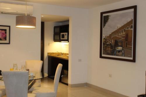 a dining room and kitchen with a table and chairs at Mesón de la Luna Hotel & Spa in Mérida