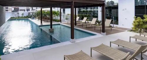 una piscina en un edificio con sillas alrededor en Apart hotel, 2 quartos - Caminho das árvores, en Salvador