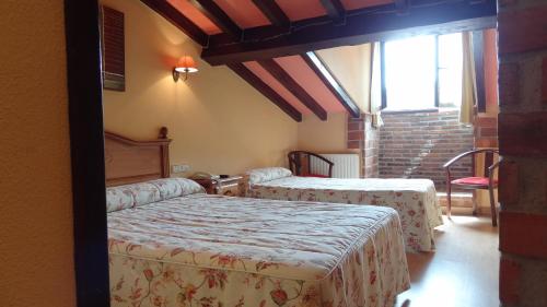 1 dormitorio con 2 camas y ventana en Hotel Trapa, en Soto de Cangas
