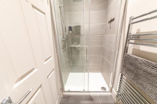 y baño con ducha y puerta de cristal. en NEWLY REFURBISHED House - FREE Wi-Fi! en Wyken