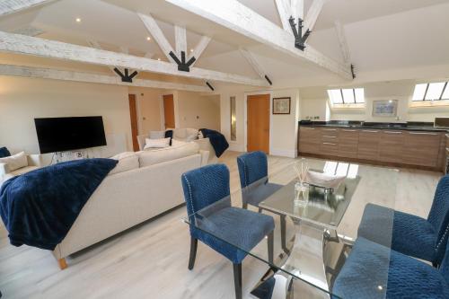 a living room with a couch and a table at The Penthouse in Helston