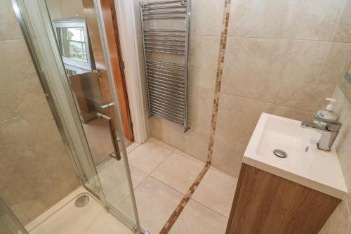 a bathroom with a shower and a sink at The Penthouse in Helston