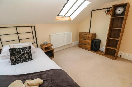 a bedroom with a bed and a clock on the wall at The Penthouse in Helston