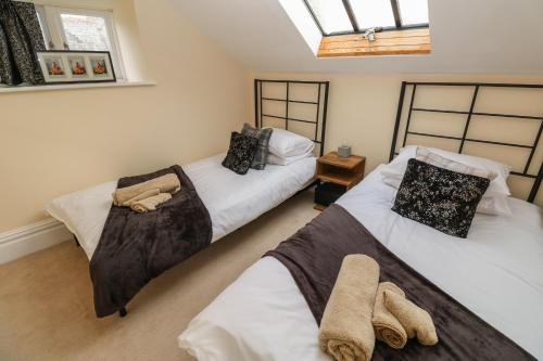 a bedroom with two beds and a window at The Penthouse in Helston