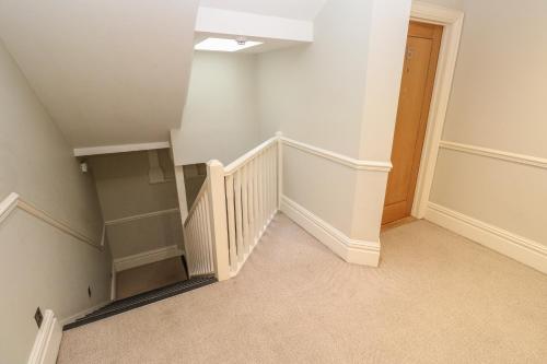 an empty room with stairs and a stair case at The Penthouse in Helston