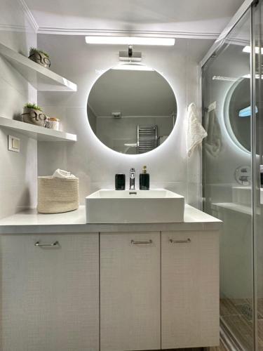 a white bathroom with a sink and a mirror at Comfort inn in Athens