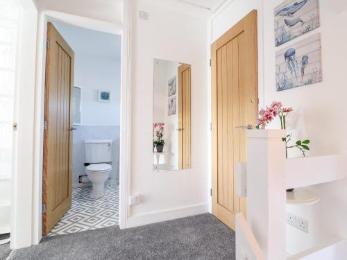 a bathroom with a toilet and a doorway at Sea Breeze in Porthmadog
