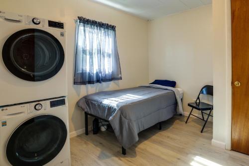 een kleine kamer met een bed en een wasmachine bij Waterfront Rock Point Vacation Rental with Sunroom! 