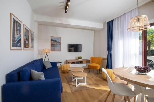 a living room with a blue couch and a table at Villa Beller New in Ičići