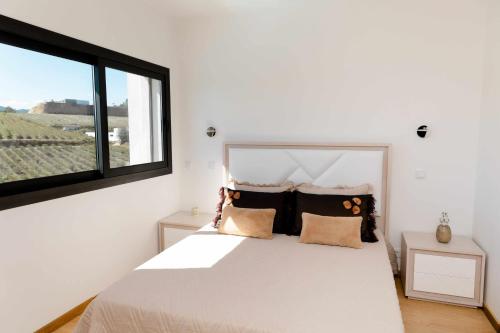 um quarto com uma cama branca e uma janela em Casa dos Mirtilos Duke T8 em Celorico de Basto