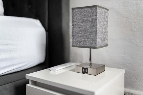 a lamp on a night stand next to a bed at Hotel Haus Biggen in Attendorn