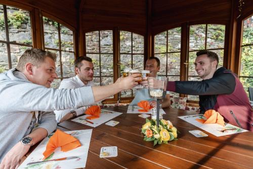 a group of men sitting around a table drinking champagne at Hotel Haus Biggen in Attendorn
