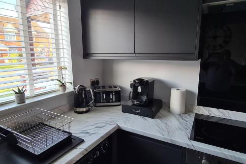 a kitchen with a counter top with a coffee maker at Runway Airbnb in Manchester