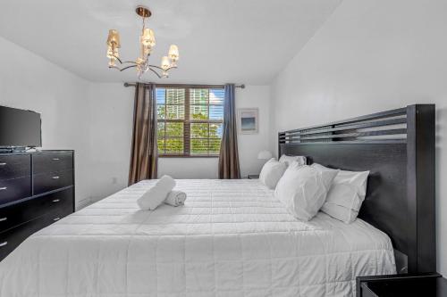 een slaapkamer met een groot wit bed met een teddybeer erop bij Modern 2-bedroom condo in Aventura in Aventura