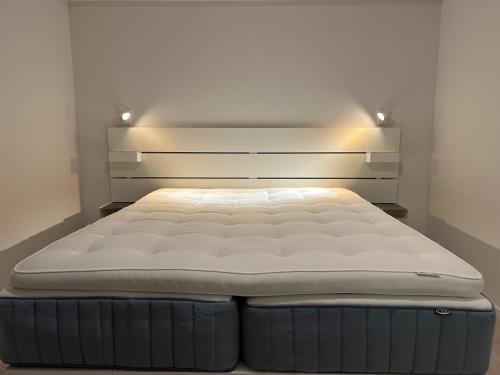 a bed in a room with a white mattress at Sørlandsidyll med svømmebasseng! in Kristiansand