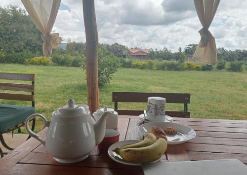 a table with a tea pot and bananas on it at KIJIJI VILLAGE in Emali