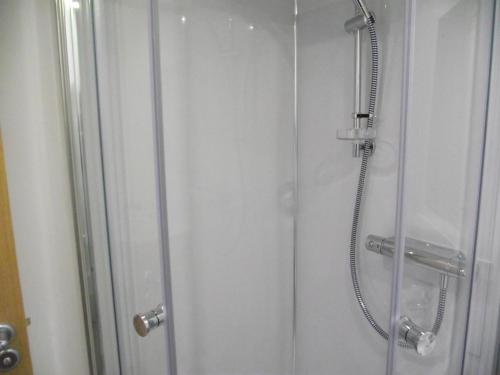 a shower stall with a glass door with a shower at 6B Church St. Dingwall Apartment in Dingwall