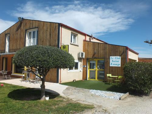 un edificio con un árbol delante de él en Logis hôtel restaurant Le clos saint loup en Bram