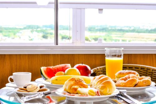 un tavolo con piatti per la colazione e un bicchiere di succo d'arancia di Hotel Lafayette a Itaquaquecetuba