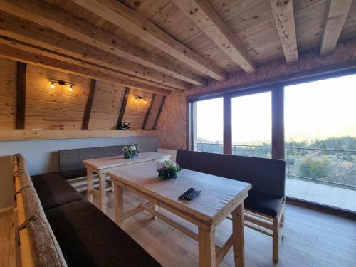 a living room with a table and a couch at Vila Suvo vrelo sa unutrašnjim bazenom i saunom Jahorina in Jahorina