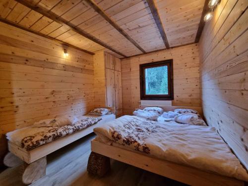 a bedroom with two beds in a log cabin at Vila Suvo vrelo sa unutrašnjim bazenom i saunom Jahorina in Jahorina