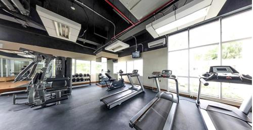 a gym with several treadmills and elliptical machines at Cosmo Residence “ 1 BR ” at Thamrin City in Jakarta