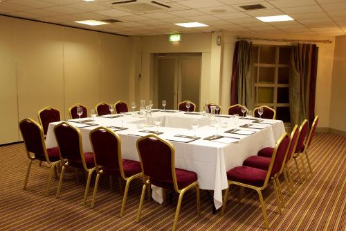 a conference room with a white table and chairs at Waterfoot Hotel in Derry Londonderry