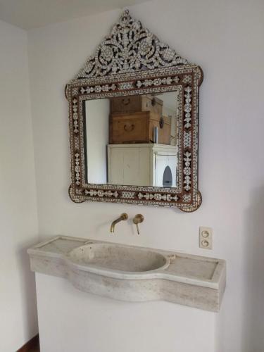 La salle de bains est pourvue d'un lavabo en pierre et d'un miroir. dans l'établissement Kasteel Sint-Flora, à Furnes