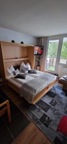 ein Schlafzimmer mit einem großen Bett und einem großen Fenster in der Unterkunft Petersferienwohnung- Ferienwohnung mit Sauna, Pools und großem Balkon im Bayerischen Wald "Sankt Englmar" in Sankt Englmar
