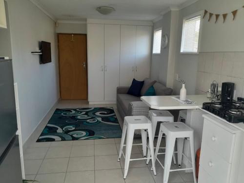 Una cocina y una sala de estar con un sofá y una mesa. en Linkside 9, en Mossel Bay
