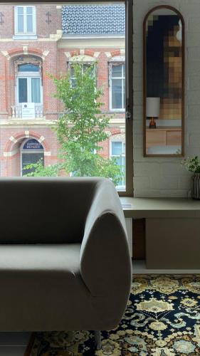 a living room with a couch and a mirror at bij DE RODE DEUR in Meppel